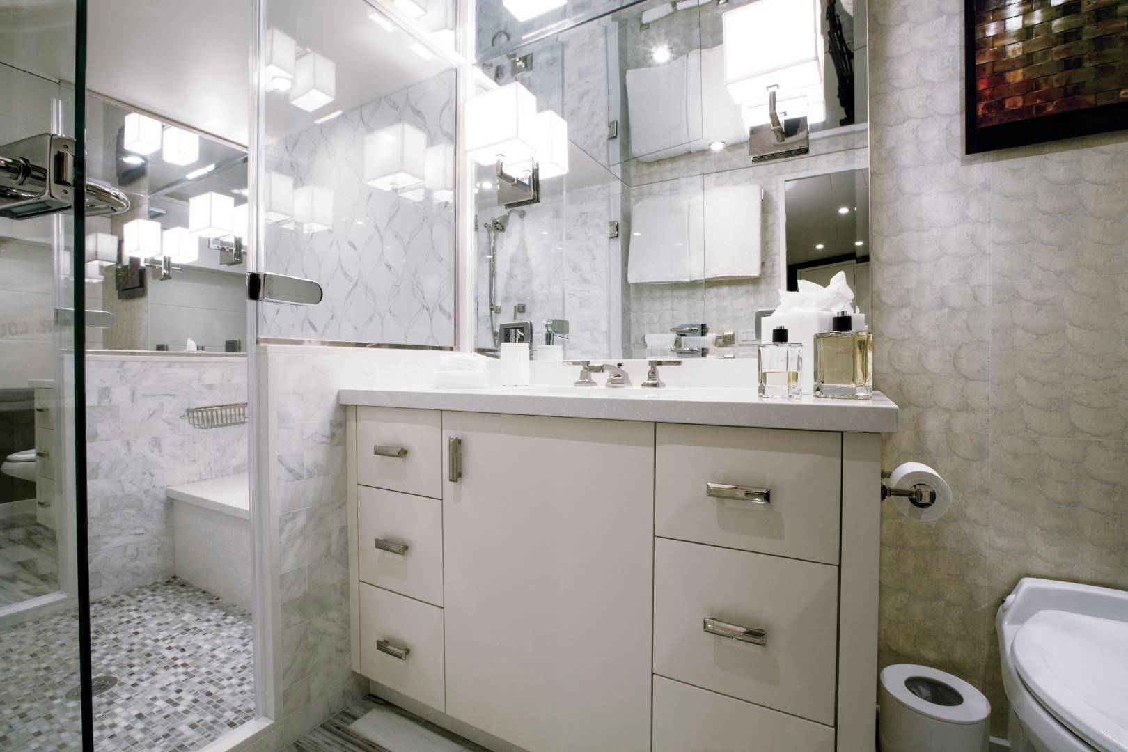 a bathroom with a glass shower aboard 2021 HATTERAS 105RPH Yacht for Sale