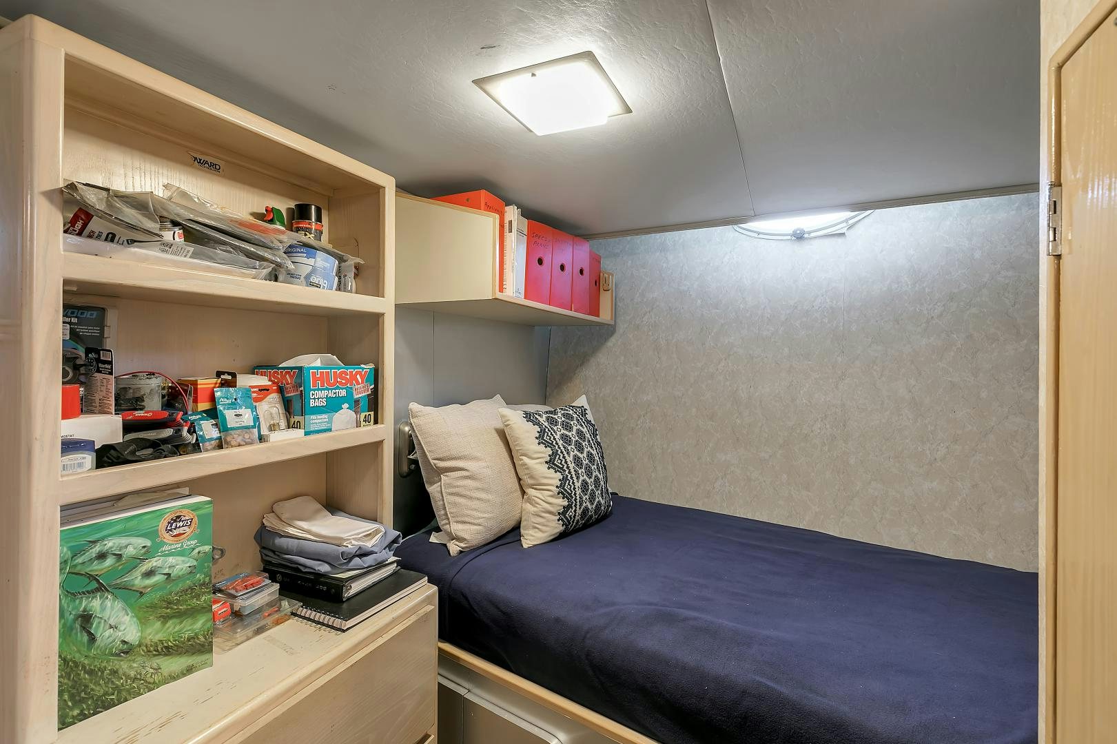 a bedroom with a bed and shelves aboard LA VIDA Yacht for Sale