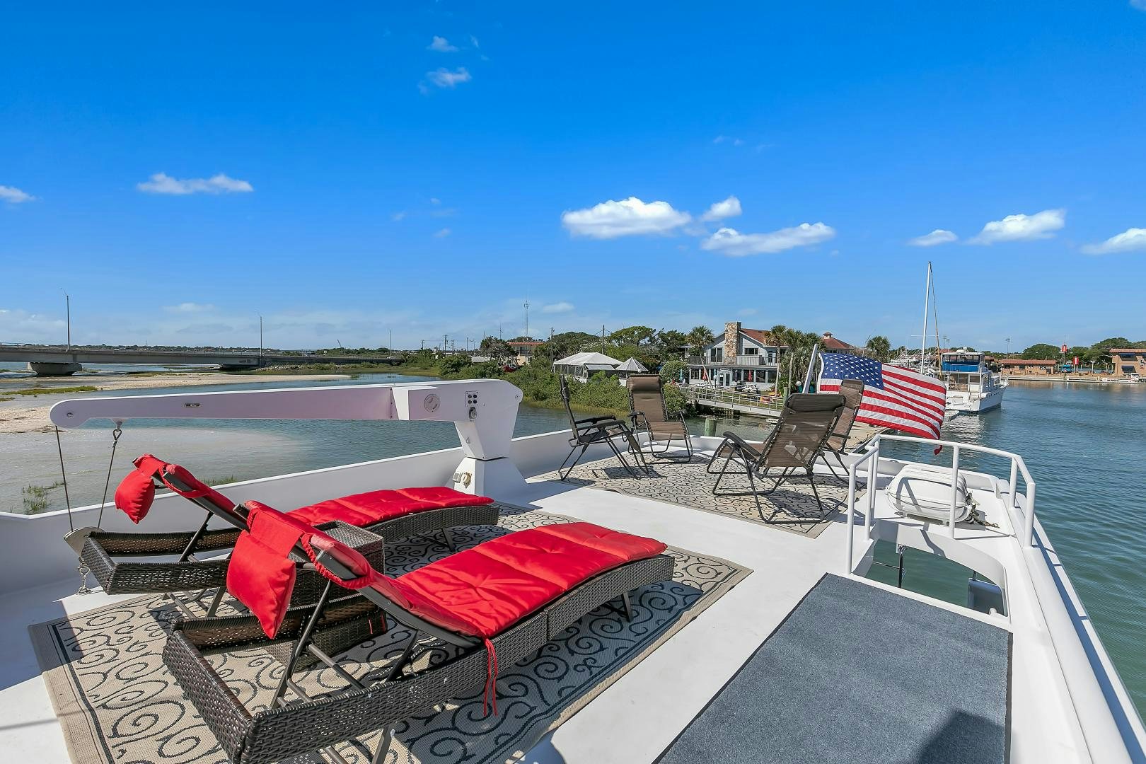 a deck with a flag on it and chairs on it aboard LA VIDA Yacht for Sale