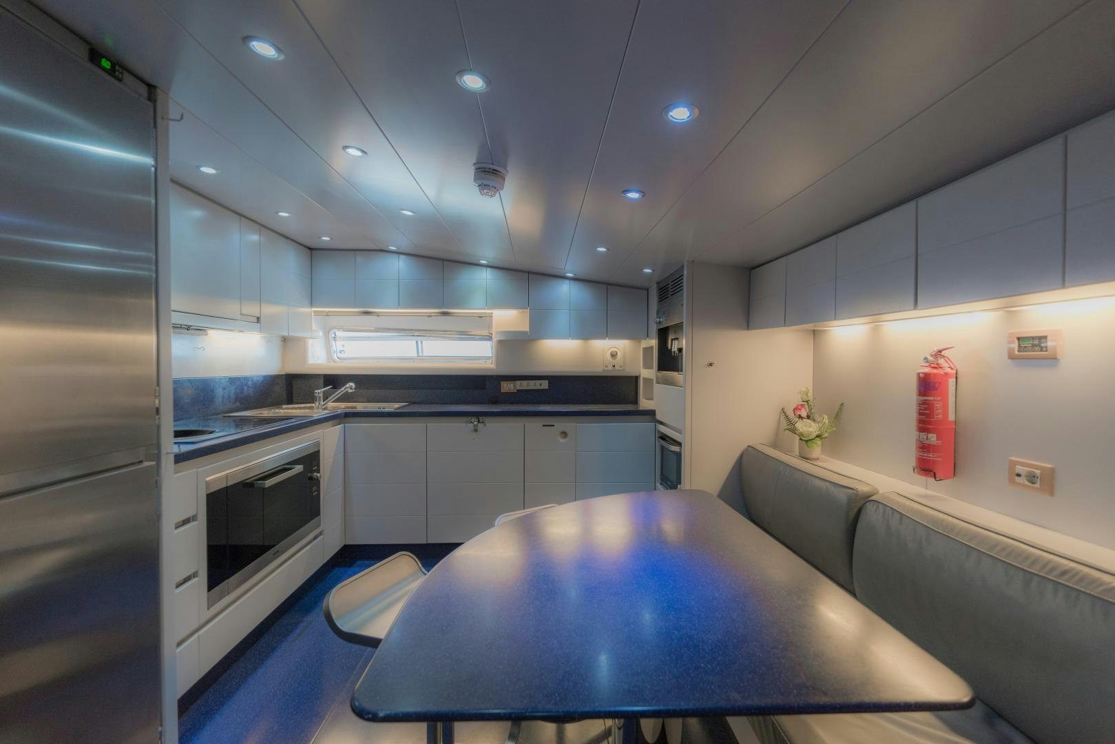 a kitchen with a table and a refrigerator aboard AVELINE Yacht for Sale