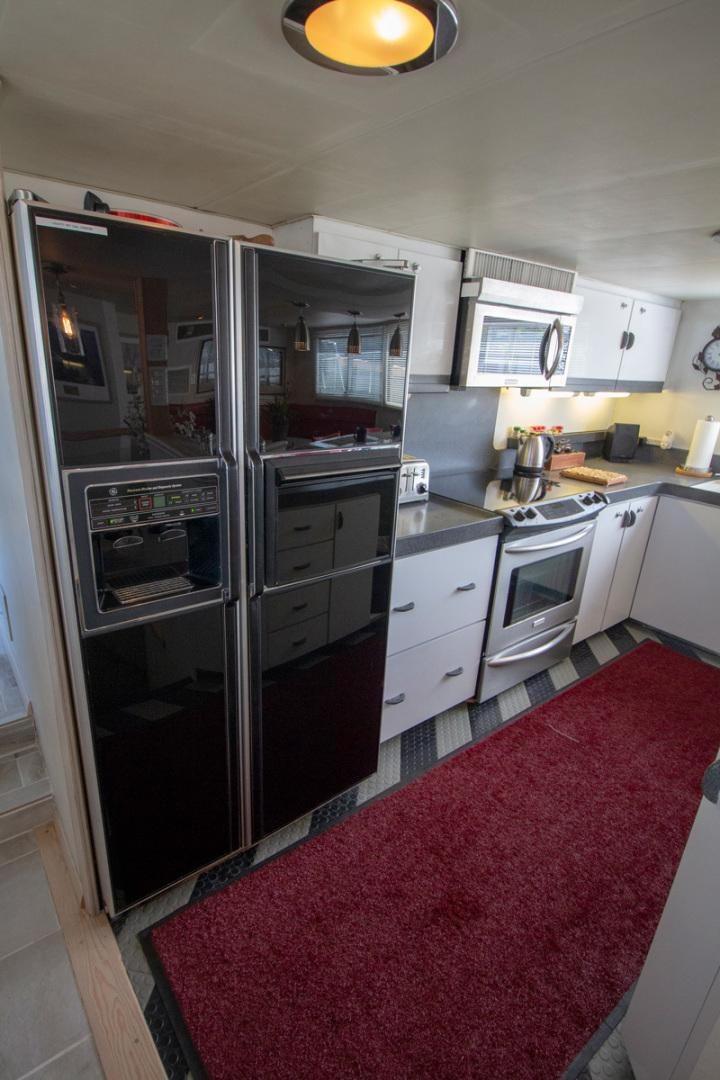 a kitchen with a red rug aboard LIQUIDITY Yacht for Sale
