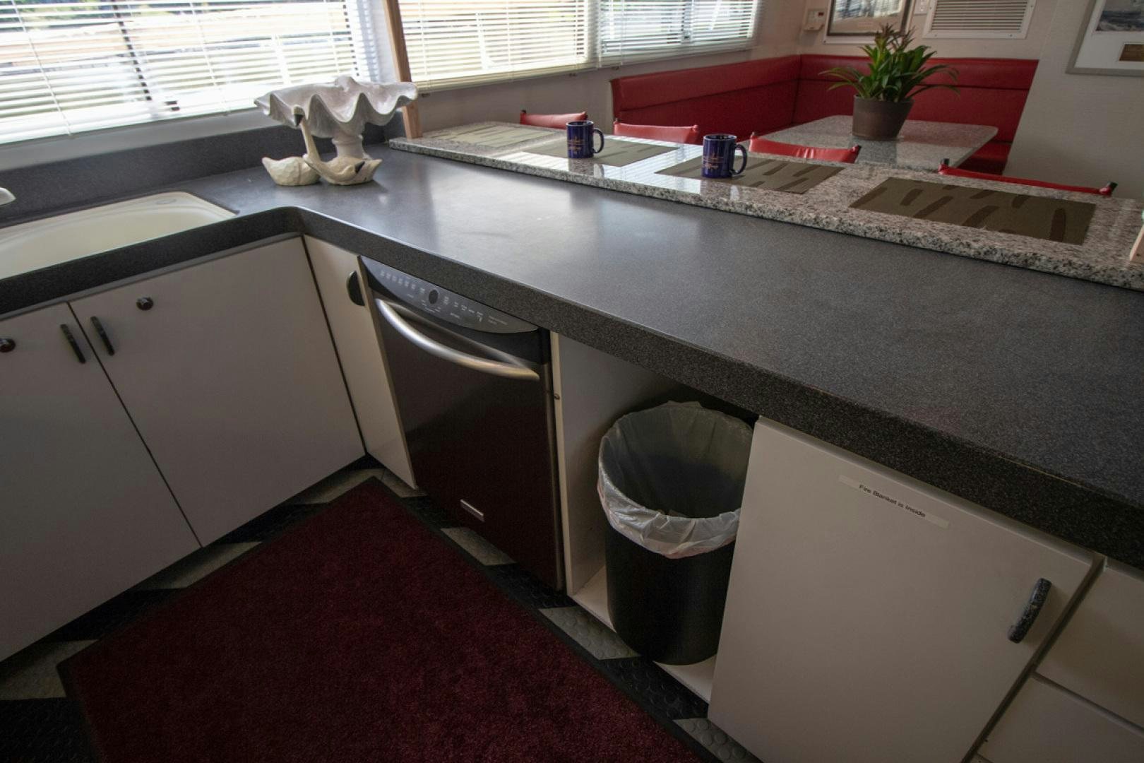 a kitchen with a sink and a trash can aboard LIQUIDITY Yacht for Sale