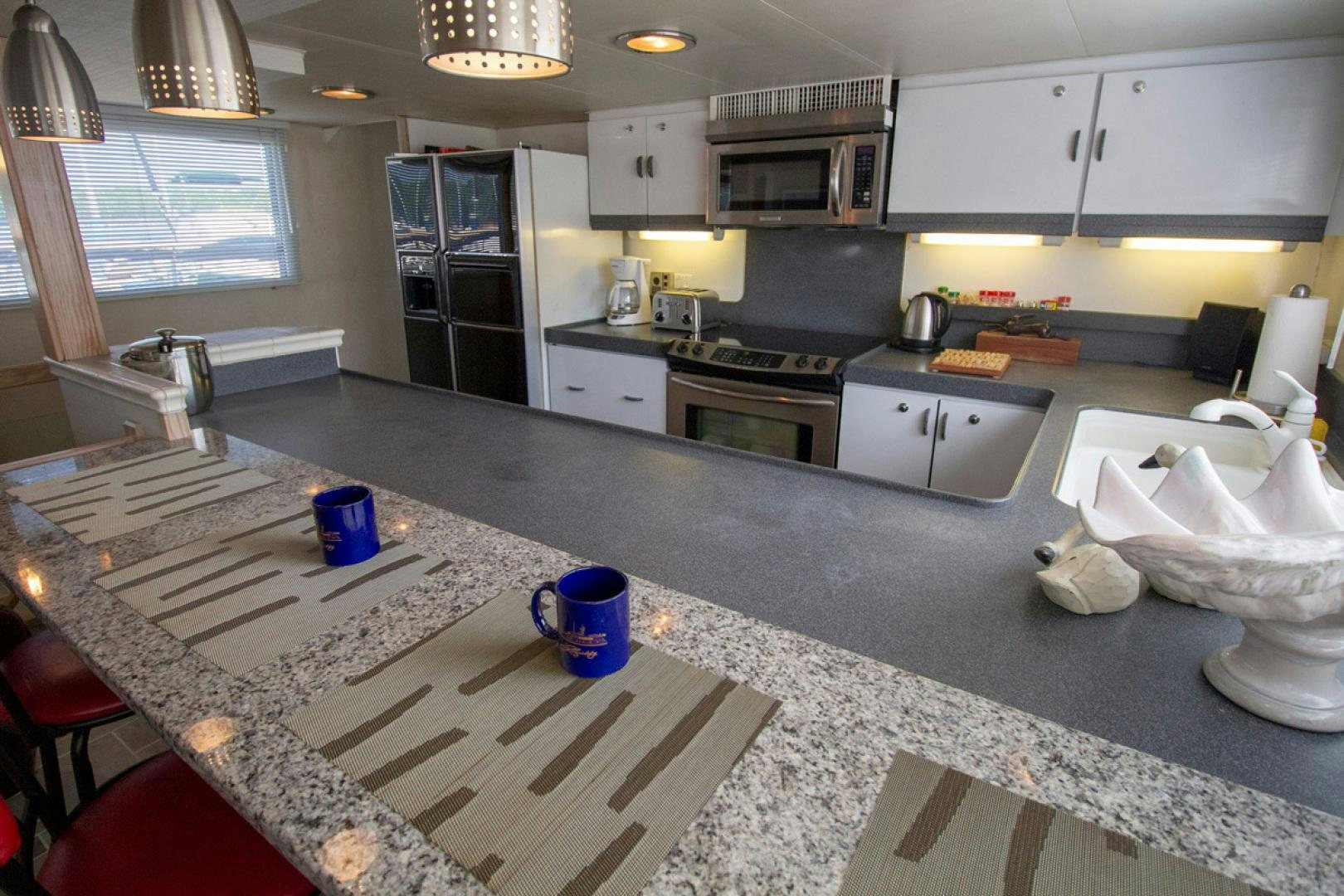 a kitchen with white cabinets aboard LIQUIDITY Yacht for Sale