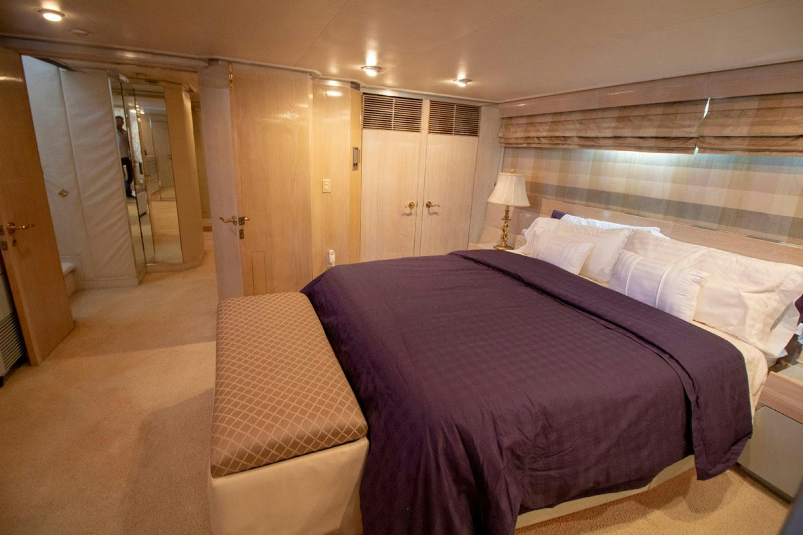 a bedroom with a bed and a lamp aboard LIQUIDITY Yacht for Sale