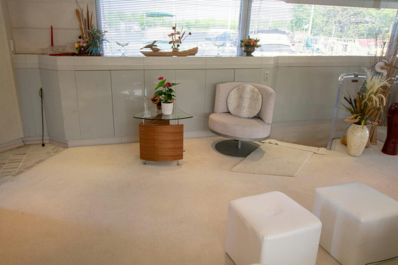 a room with a chair and a table and a plant in the window aboard LIQUIDITY Yacht for Sale