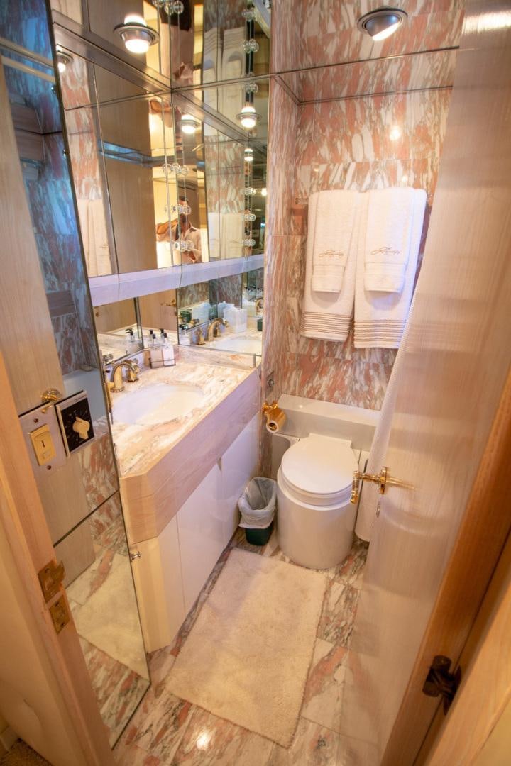 a bathroom with a toilet and tub aboard LIQUIDITY Yacht for Sale