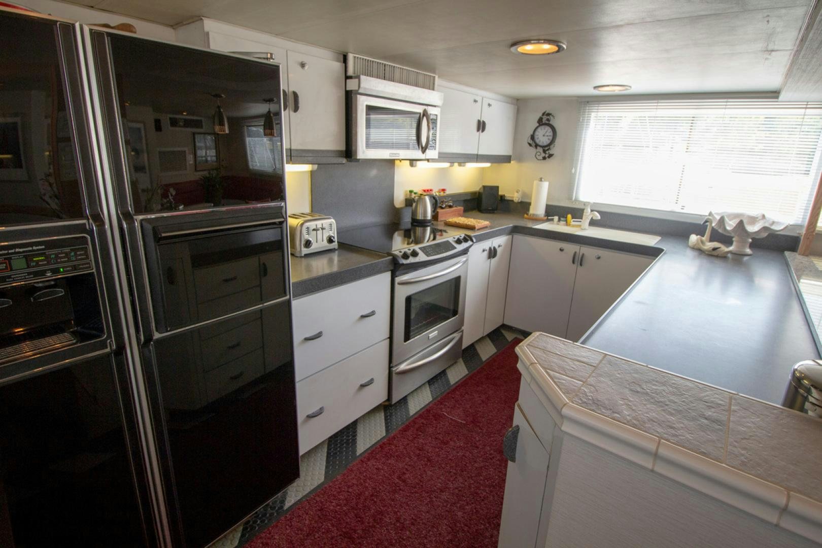 a kitchen with white cabinets aboard LIQUIDITY Yacht for Sale