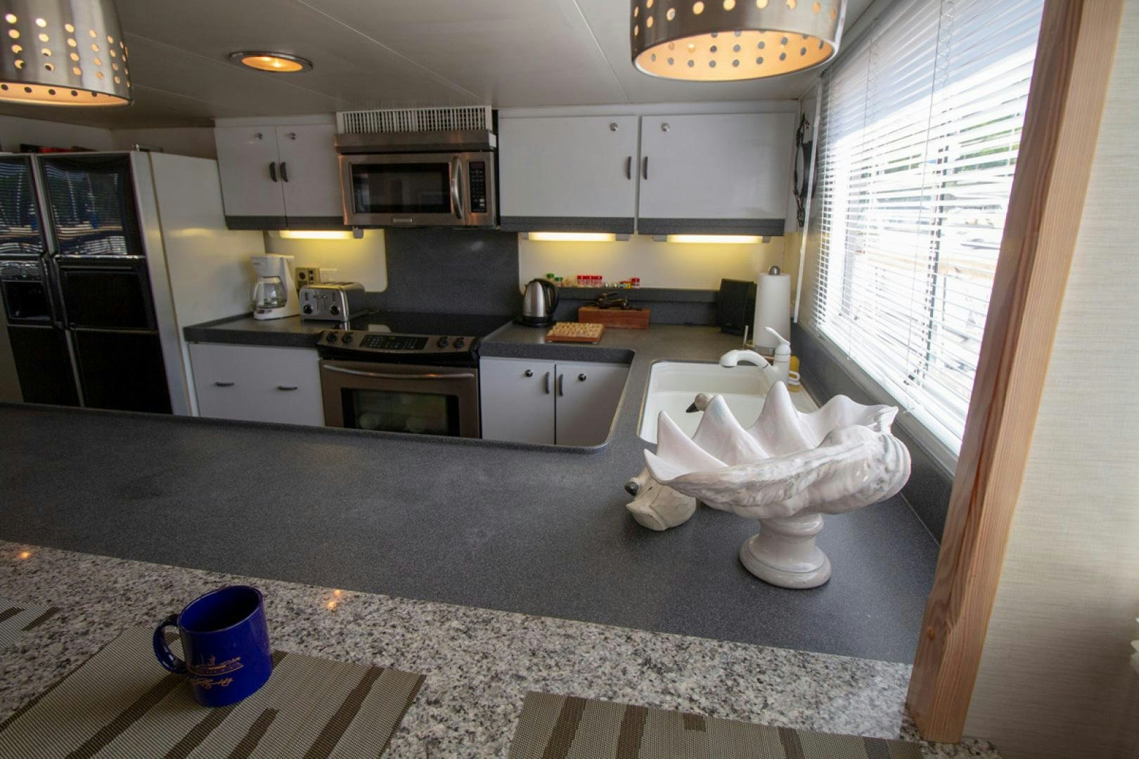 a kitchen with white cabinets aboard LIQUIDITY Yacht for Sale
