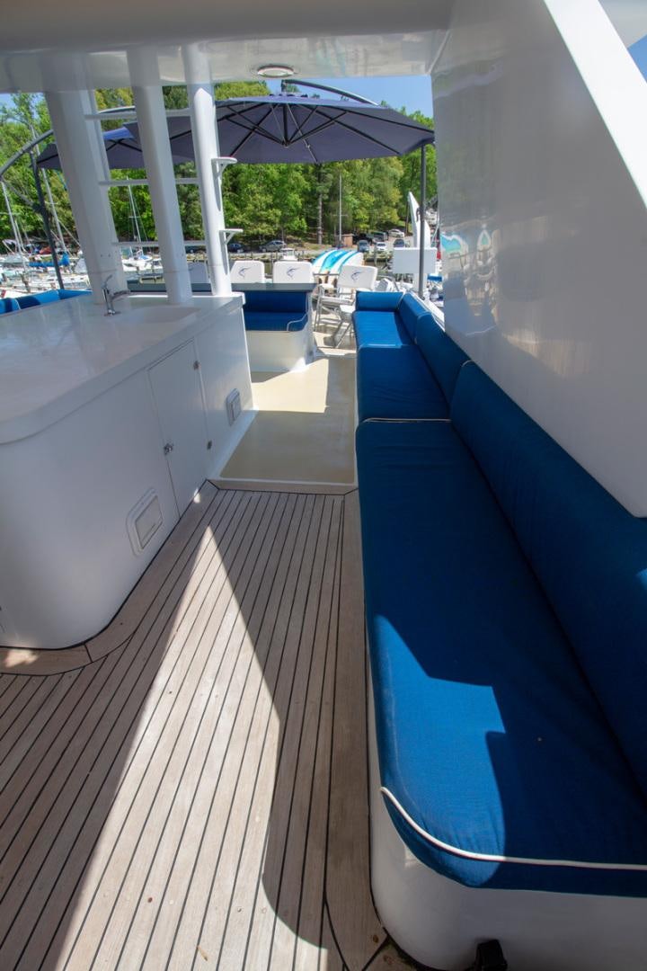 a deck with a pool and umbrellas aboard LIQUIDITY Yacht for Sale