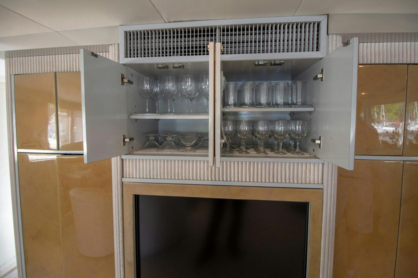 a glass cabinet with glasses and bottles aboard LIQUIDITY Yacht for Sale