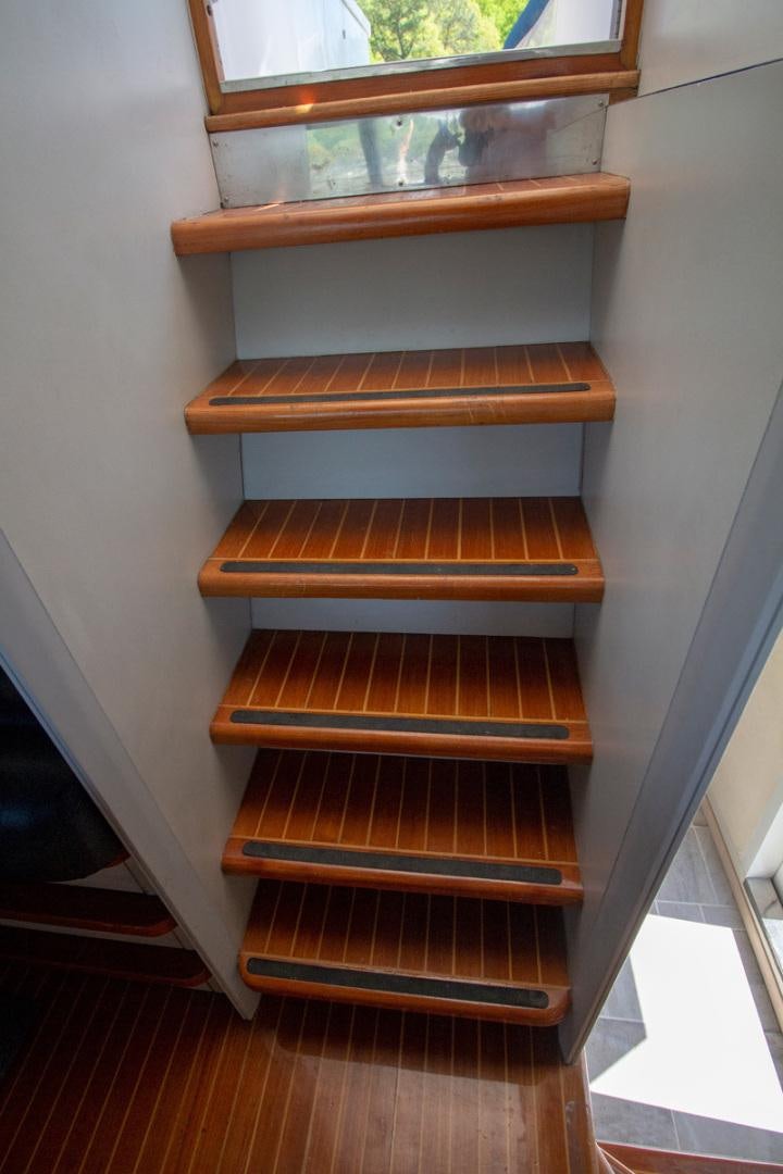 a wooden staircase with a window aboard LIQUIDITY Yacht for Sale