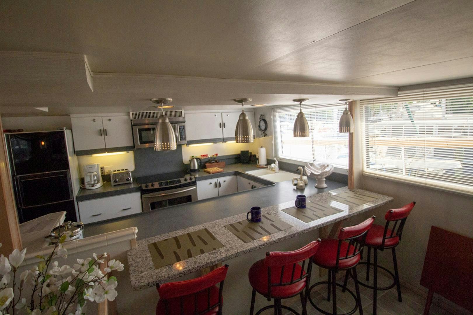 a kitchen with white cabinets aboard LIQUIDITY Yacht for Sale