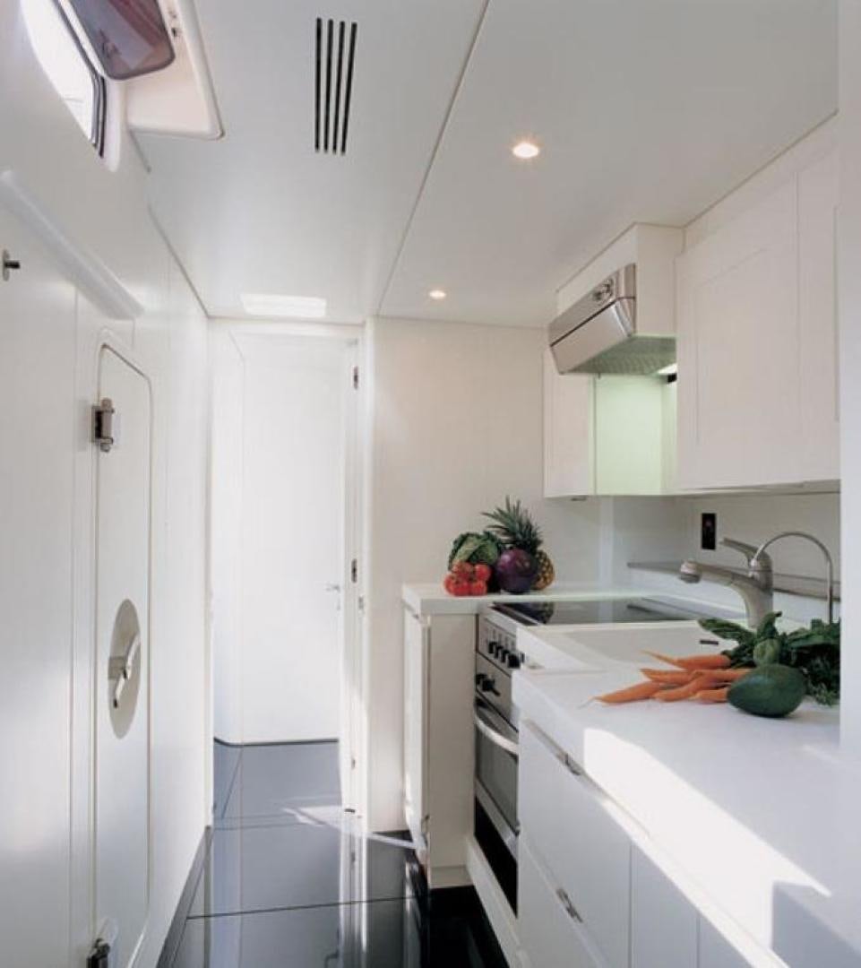 a kitchen with white cabinets aboard DARK SHADOW Yacht for Sale
