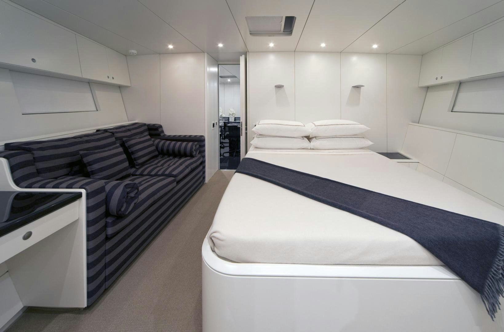 a room with a bed and a desk aboard DARK SHADOW Yacht for Sale