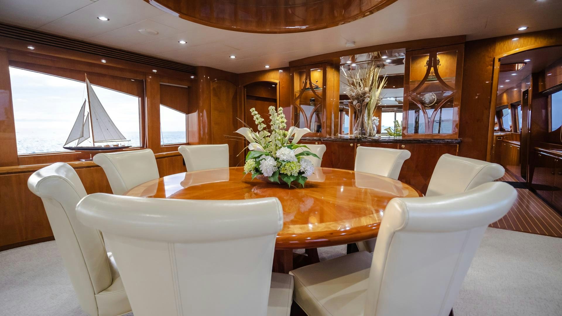 a room with a table chairs and flowers in it aboard VITESSE Yacht for Sale