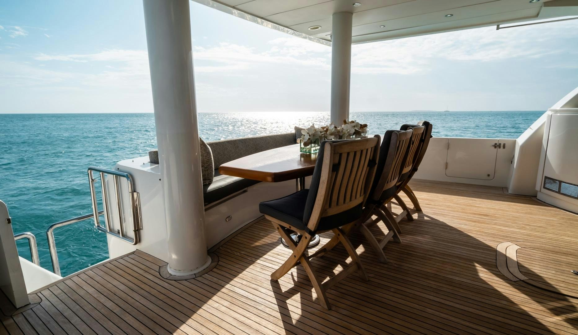 a deck with a table and chairs on it aboard VITESSE Yacht for Sale