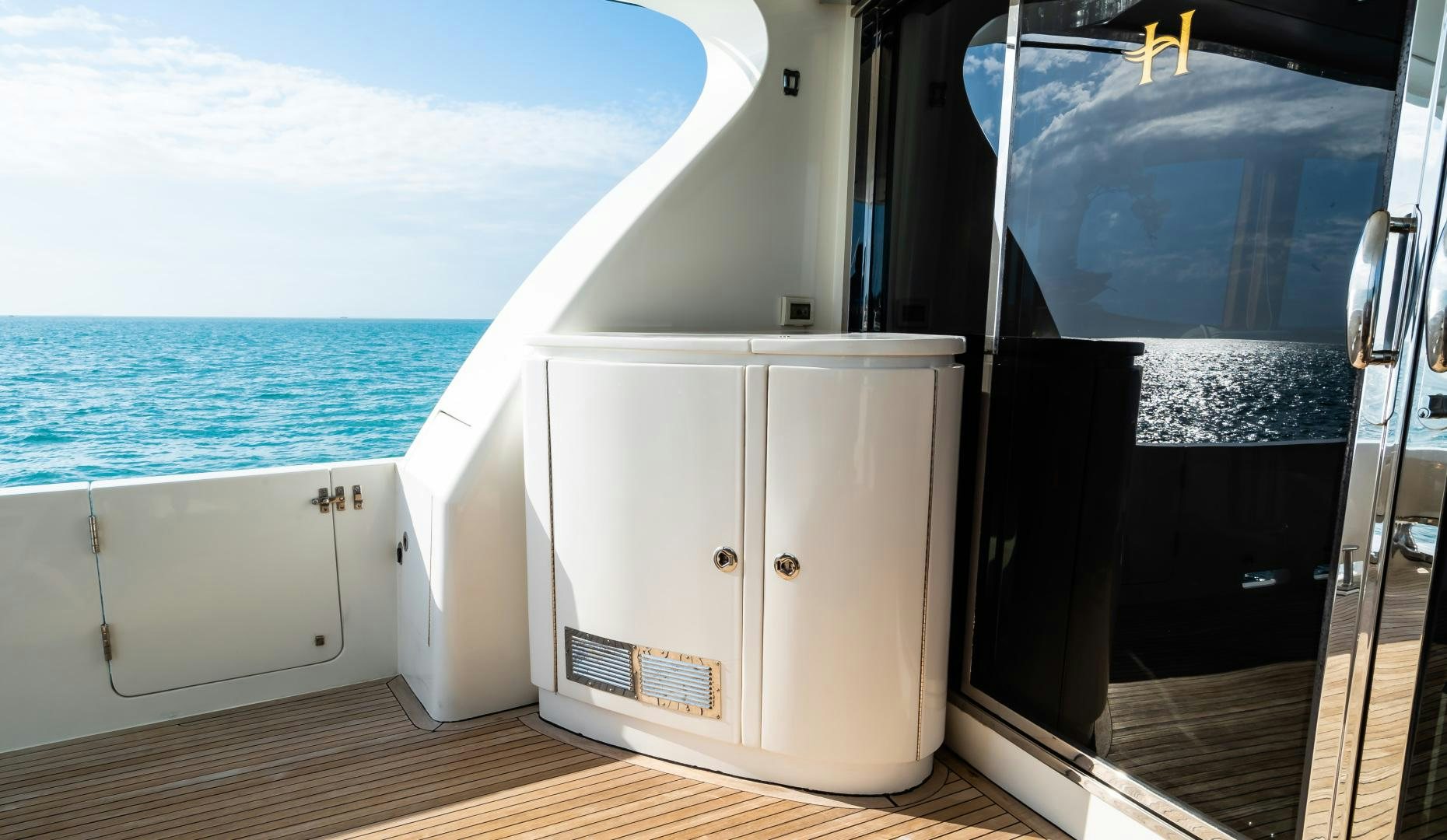 a white rectangular object on a wooden surface next to a body of water aboard VITESSE Yacht for Sale