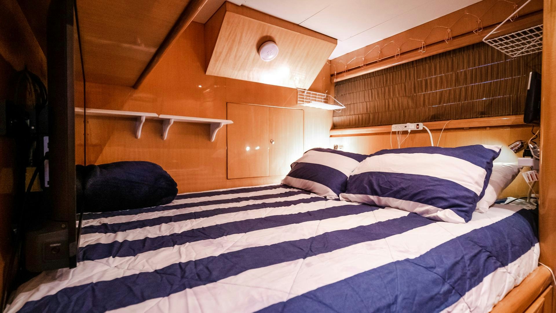 a bed with blue and white sheets aboard VITESSE Yacht for Sale