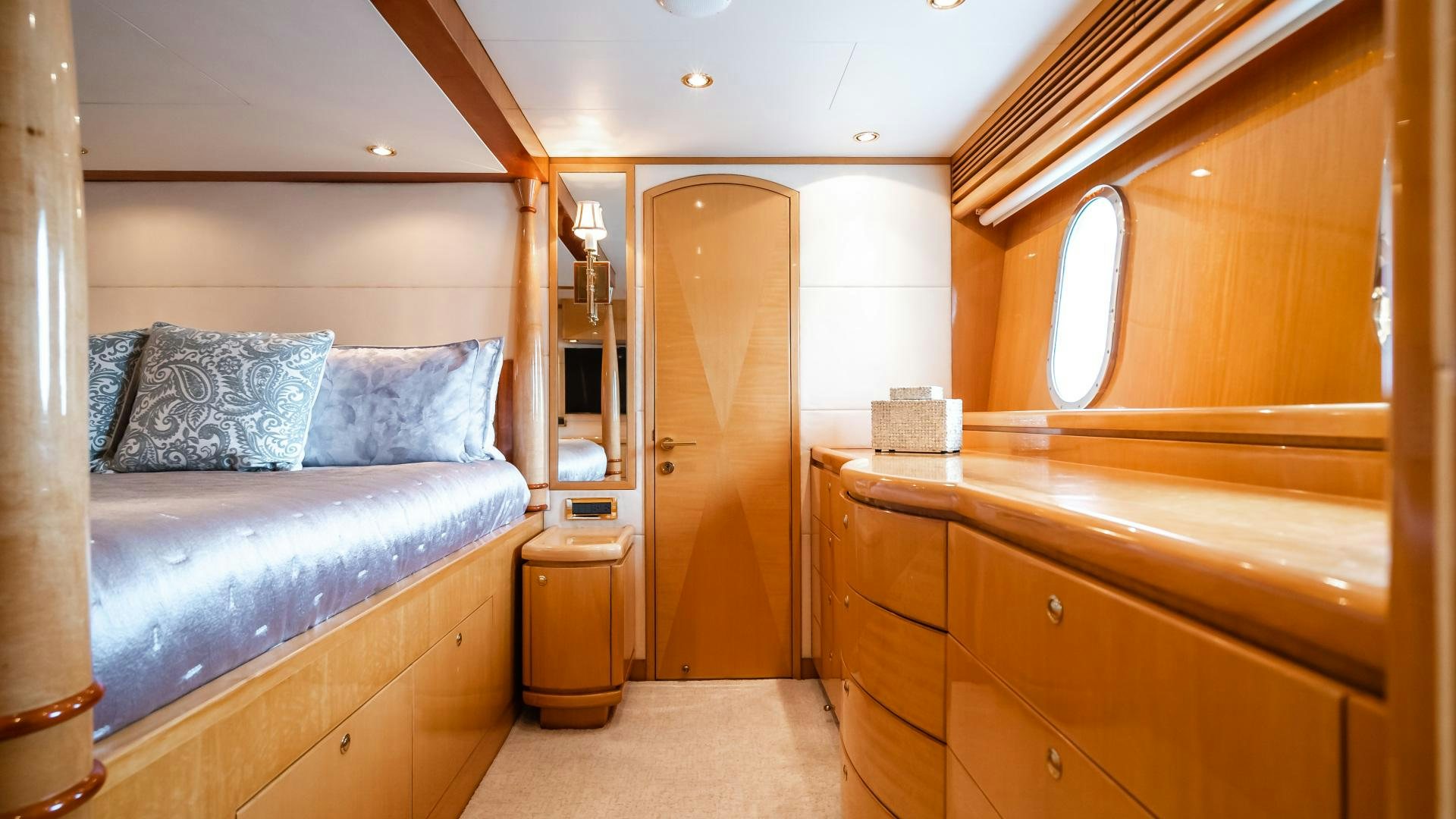 a bedroom with a bed and a dresser aboard VITESSE Yacht for Sale