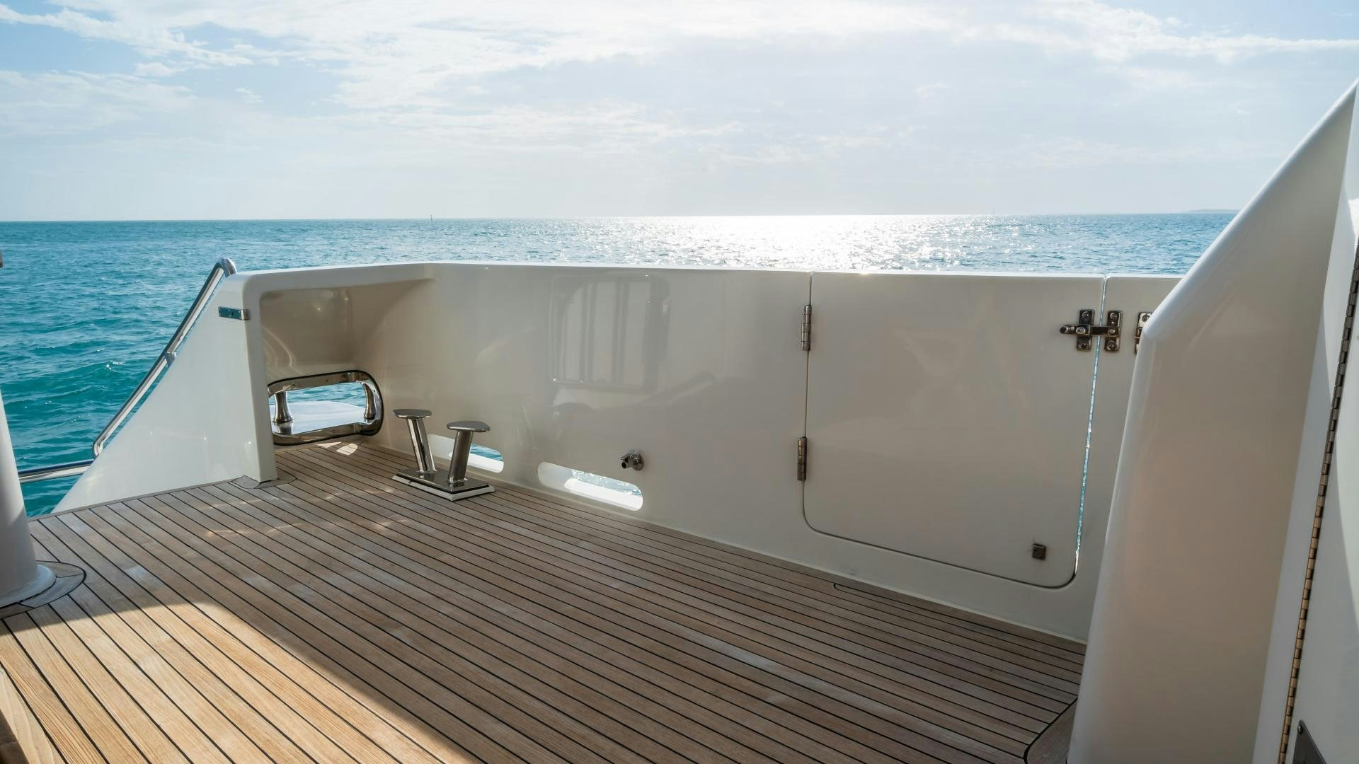 a deck with a chair on it and a body of water in the background aboard VITESSE Yacht for Sale