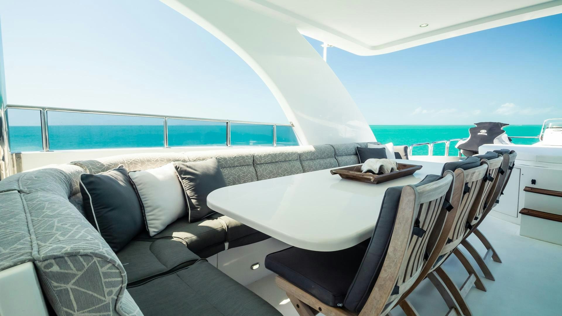 a large white lounge chair next to a large window overlooking a beach aboard VITESSE Yacht for Sale