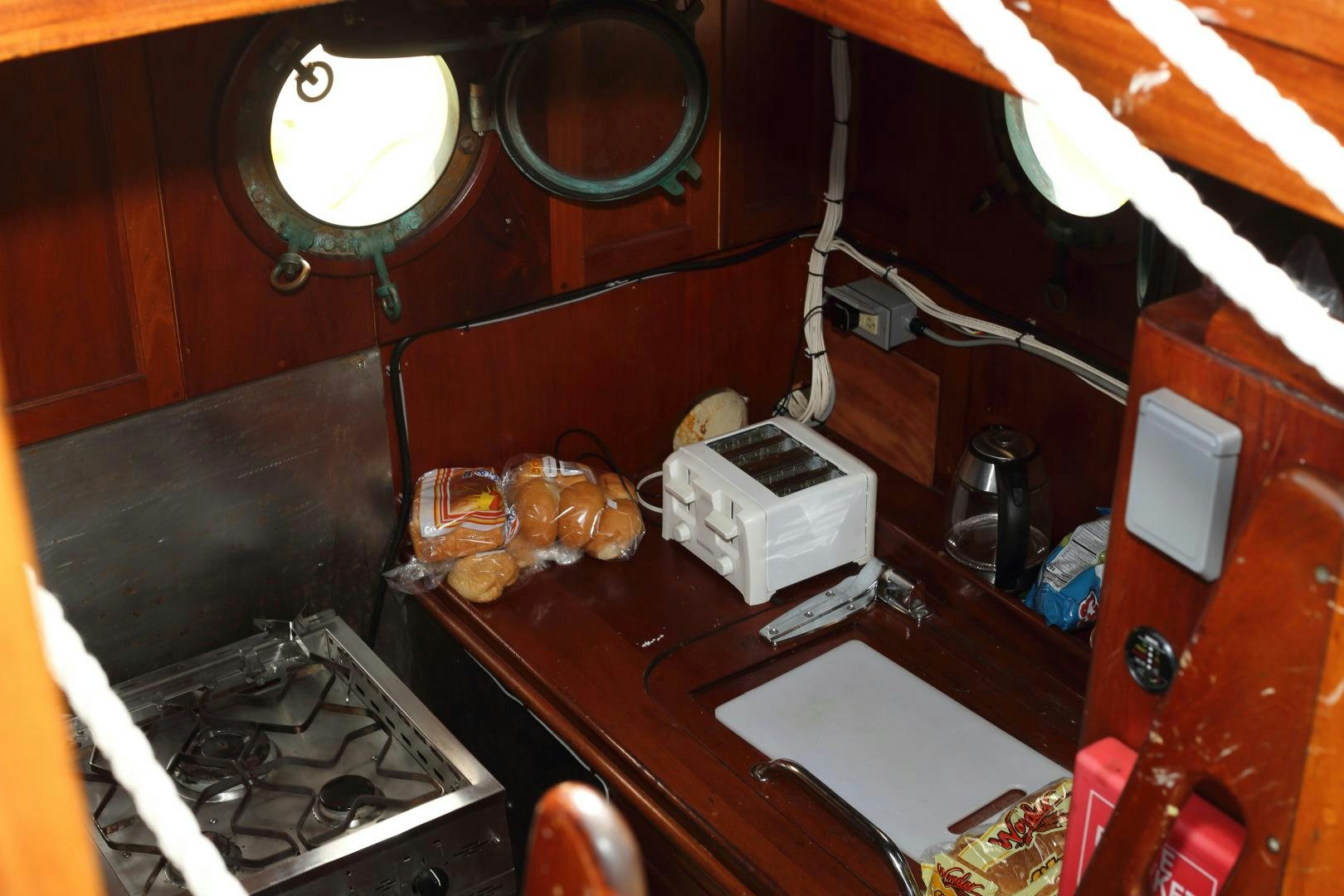 a kitchen with a stove and a shelf with objects on it aboard SCHOONER RUTH Yacht for Sale