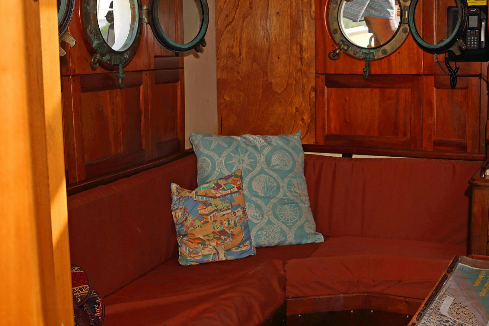 a red couch with pillows aboard SCHOONER RUTH Yacht for Sale