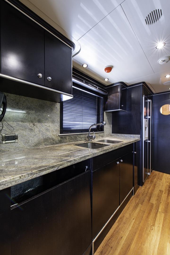 a kitchen with black cabinets aboard RUTLI E Yacht for Sale