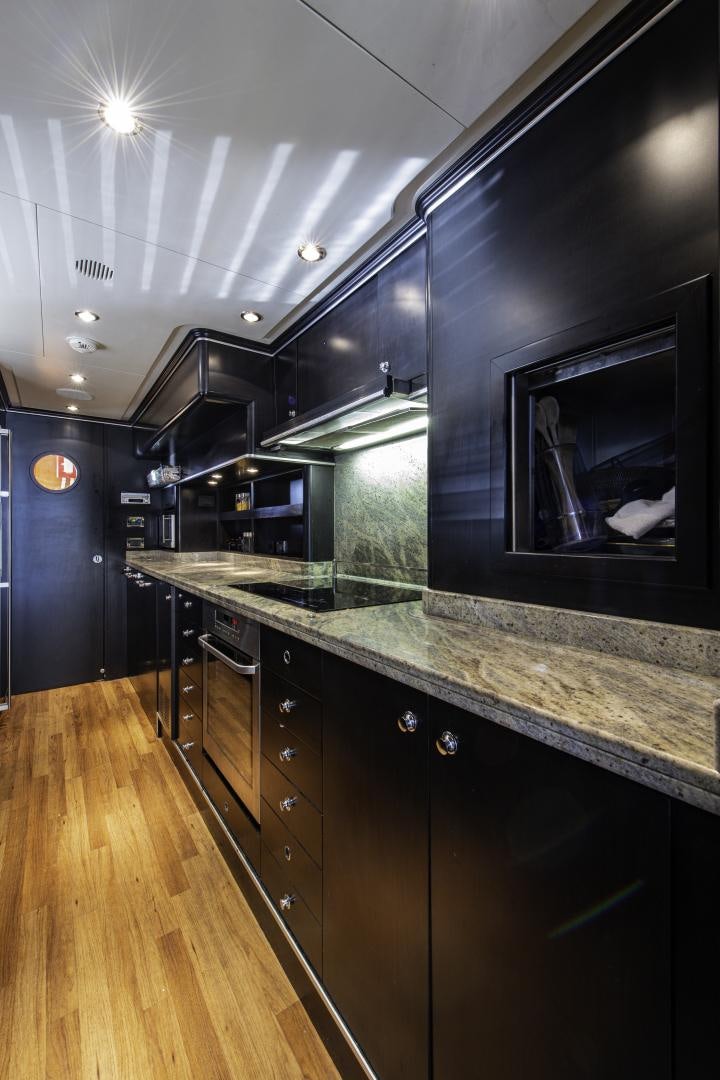 a kitchen with black cabinets aboard RUTLI E Yacht for Sale