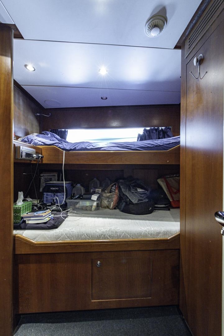 a closet with clothes and a bed aboard RUTLI E Yacht for Sale