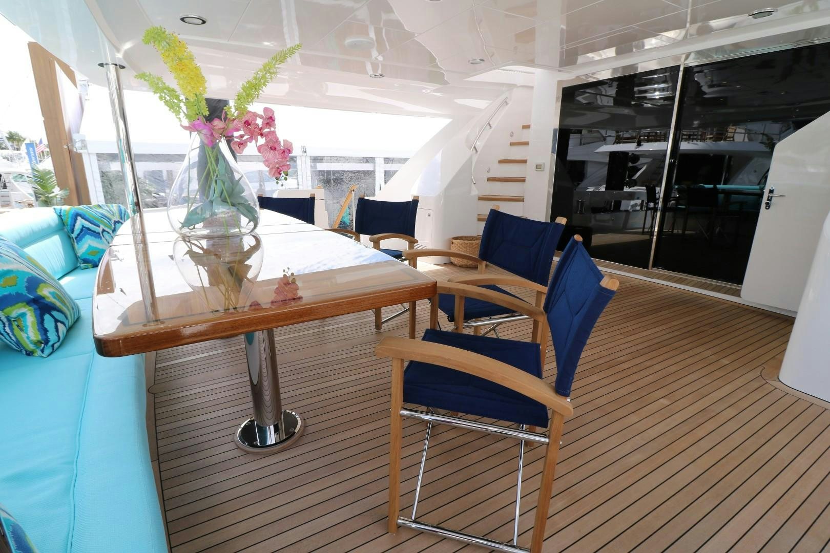 a table with chairs and a vase of flowers on it aboard LADY CARMEN Yacht for Sale