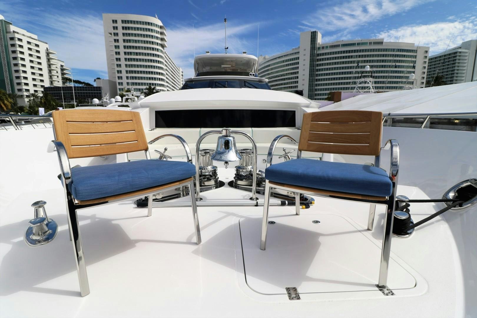 a couple of blue chairs on a white surface with buildings in the background aboard LADY CARMEN Yacht for Sale