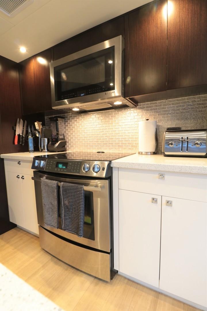 a kitchen with a stove and microwave aboard LADY CARMEN Yacht for Sale