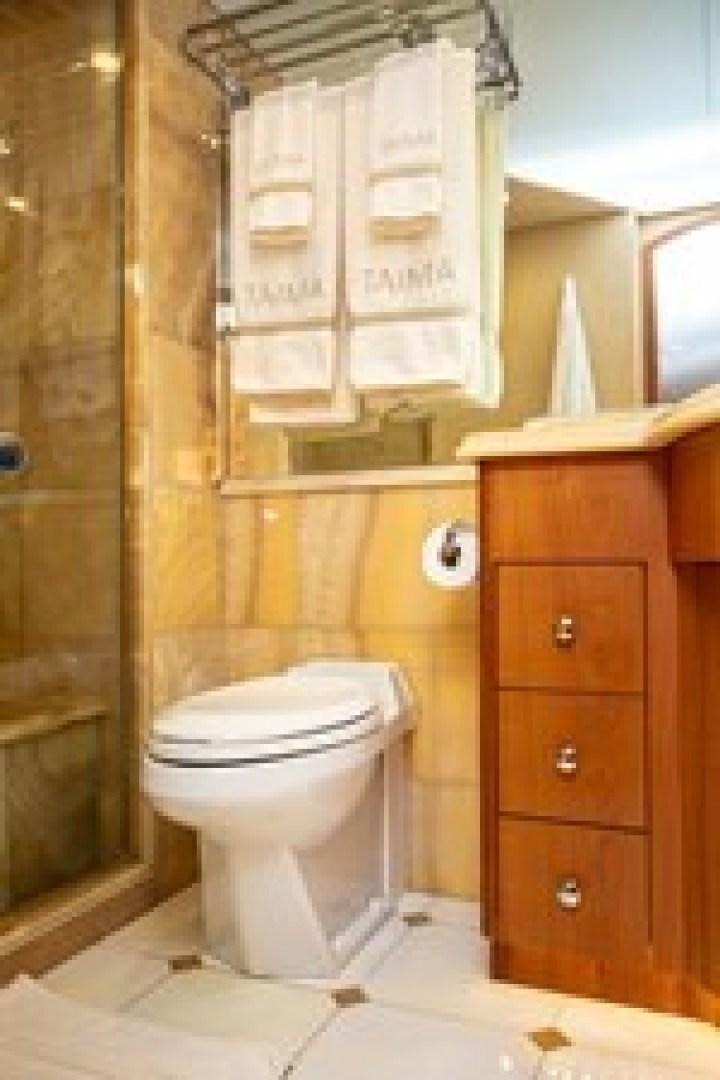 a bathroom with a toilet and a cabinet aboard TAIMA Yacht for Sale