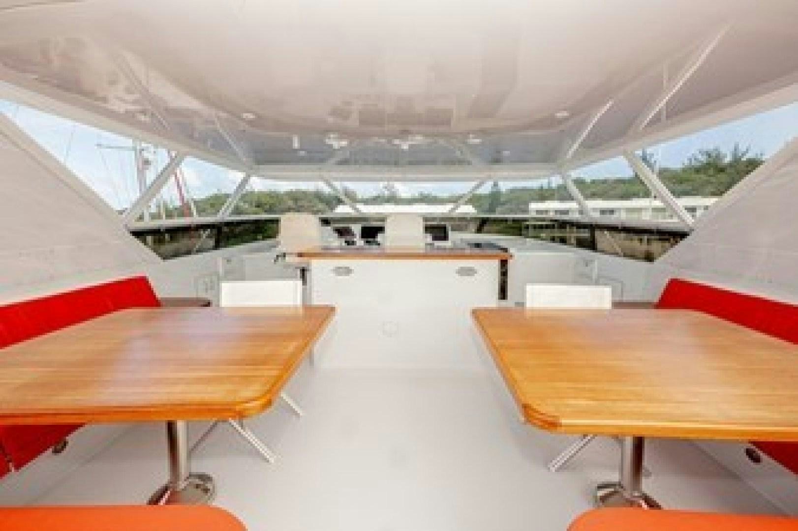 a room with tables and chairs aboard TAIMA Yacht for Sale
