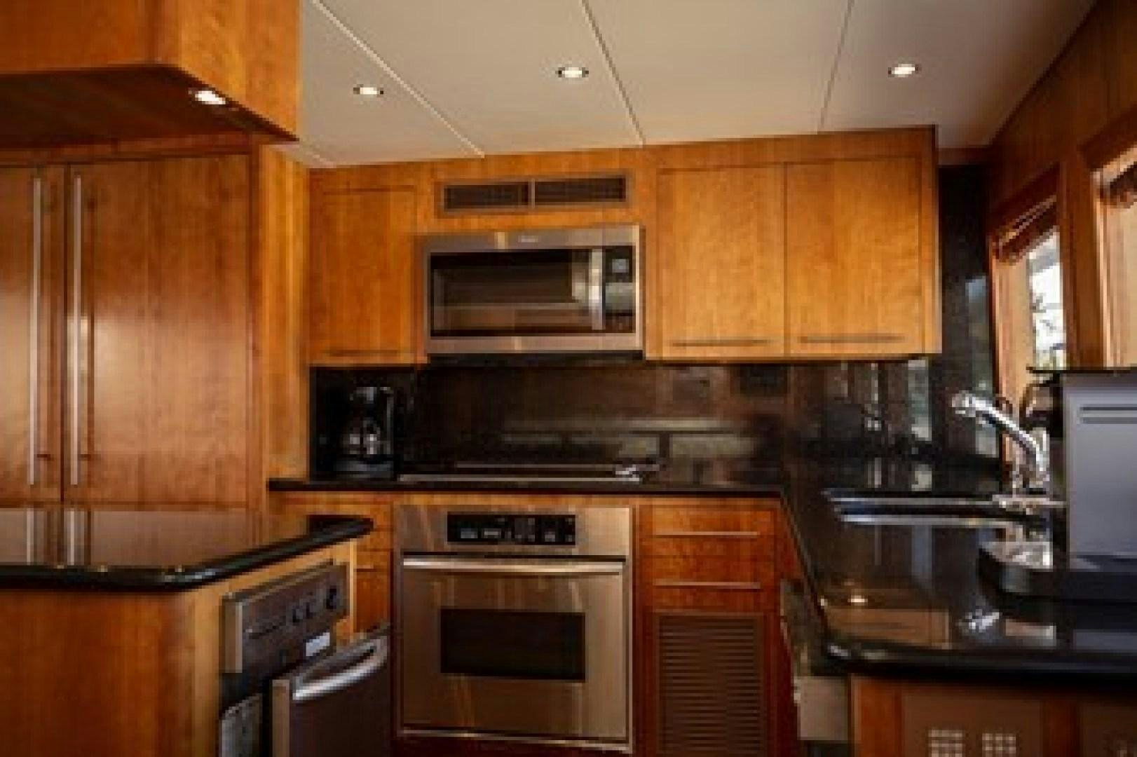 a kitchen with wooden cabinets aboard TAIMA Yacht for Sale