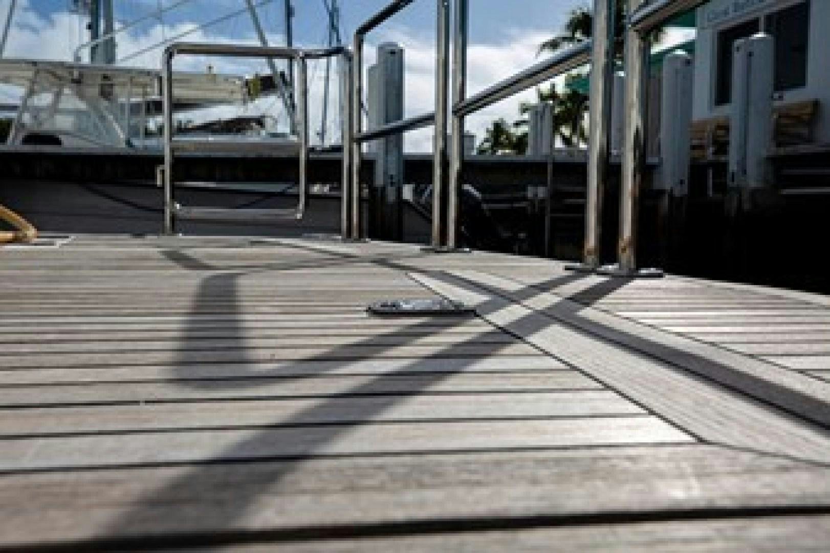 a wooden walkway with metal railings aboard TAIMA Yacht for Sale