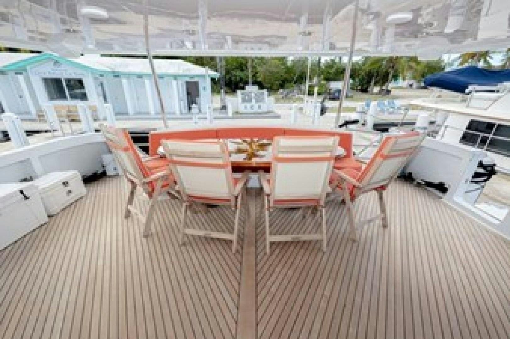 a deck with chairs and tables aboard TAIMA Yacht for Sale