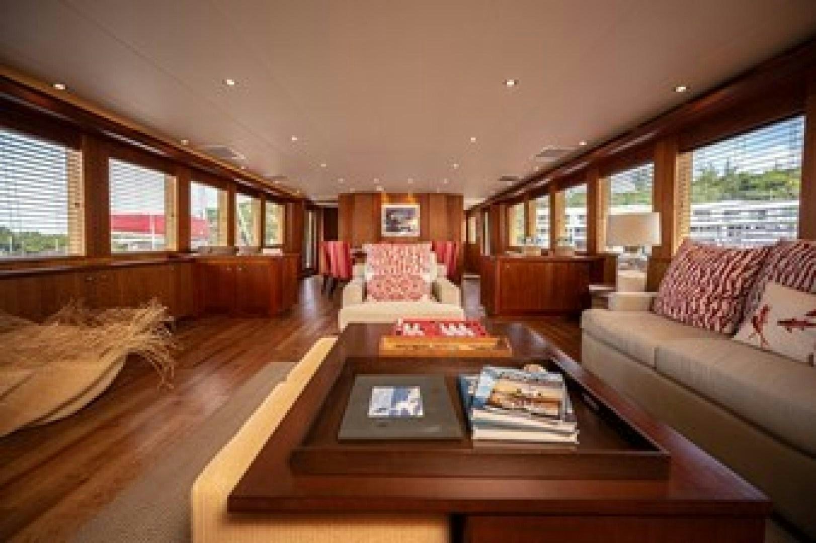 a living room with a table and couches aboard TAIMA Yacht for Sale