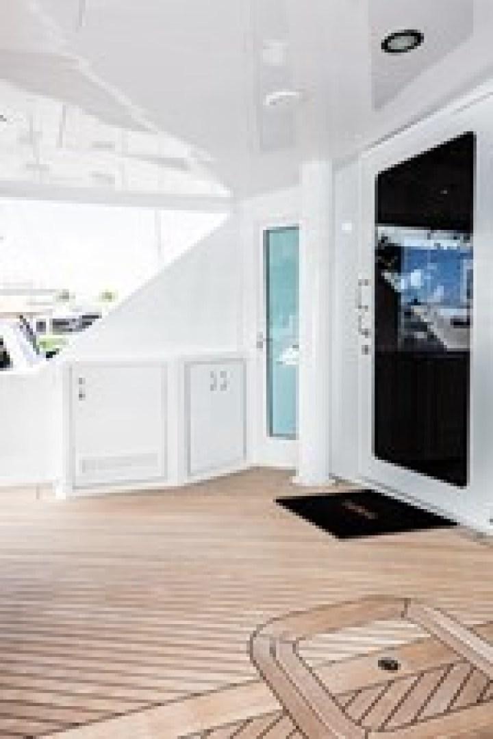 a room with a wood floor and a door with a window aboard TAIMA Yacht for Sale