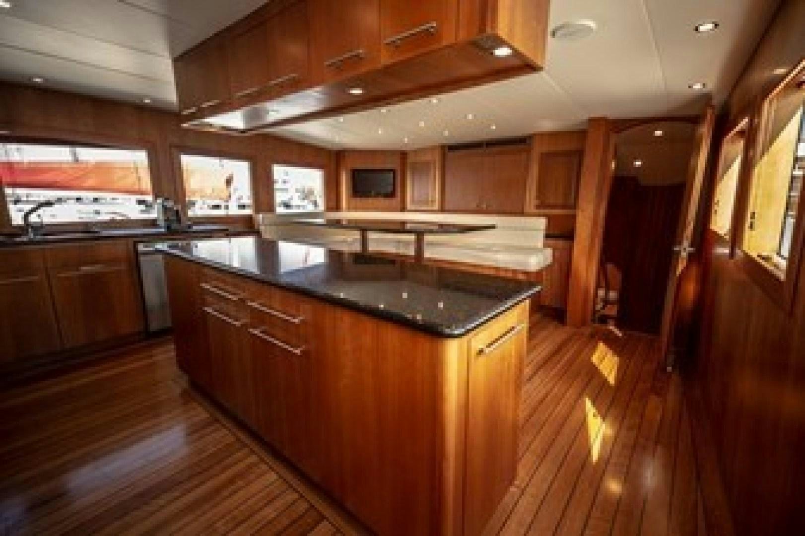 a kitchen with wooden cabinets aboard TAIMA Yacht for Sale