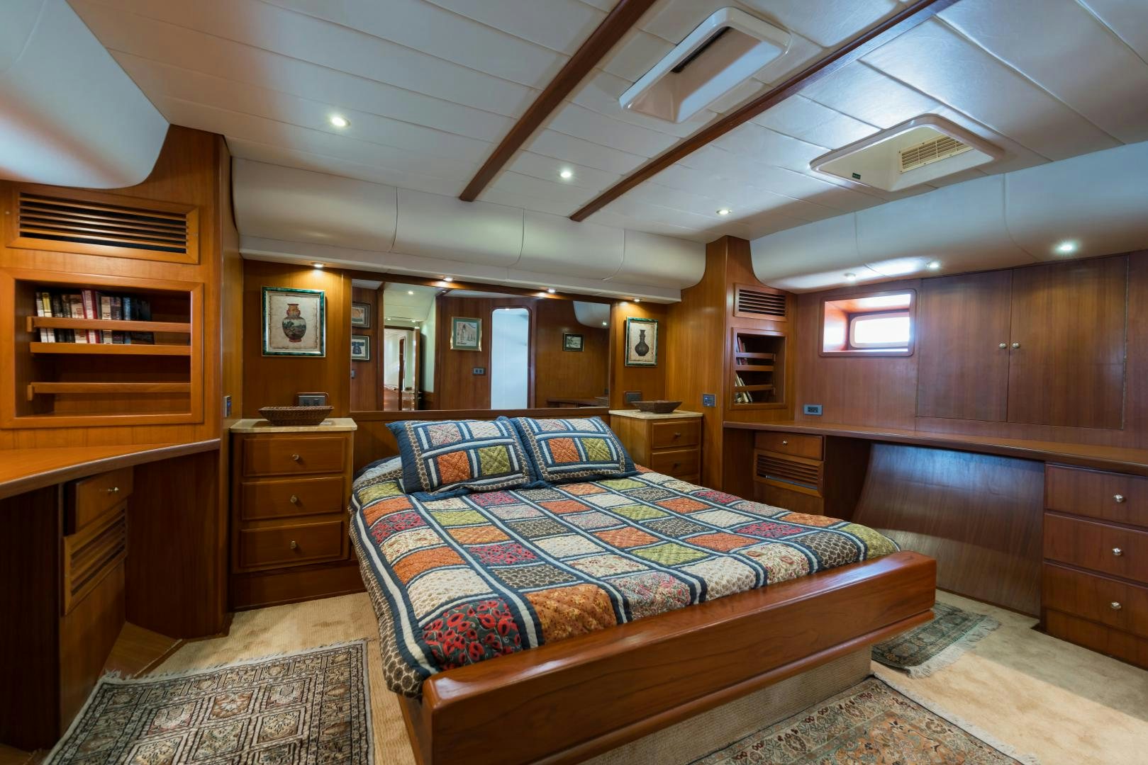 a bedroom with wood furniture aboard TARONGA Yacht for Sale