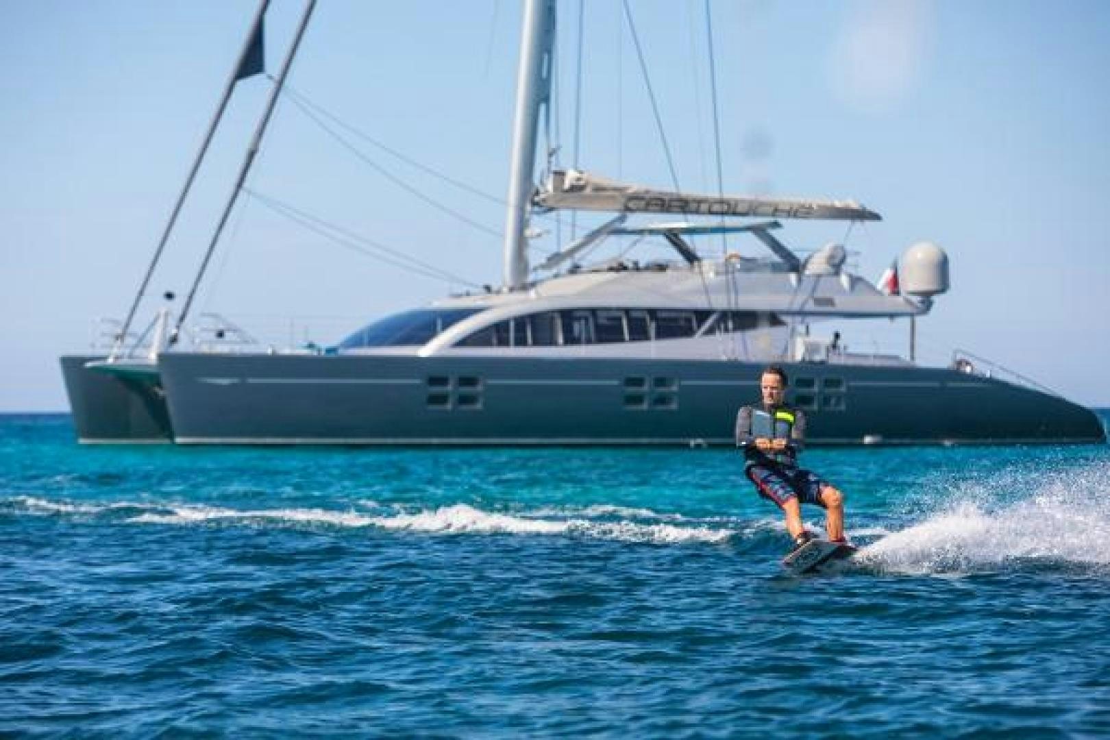 a person water skiing in front of a boat aboard CARTOUCHE Yacht for Sale