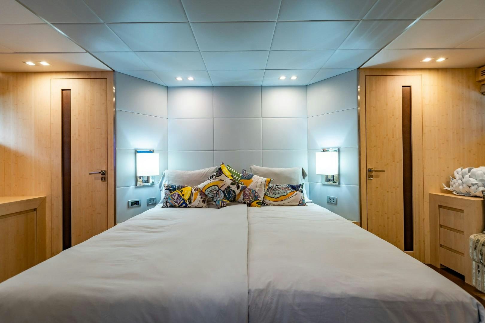 a bed with a white sheet and pillows in a hotel room aboard REVEIL Yacht for Sale