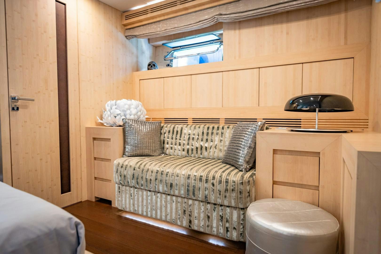 a room with a couch and a shelf with a chair aboard REVEIL Yacht for Sale