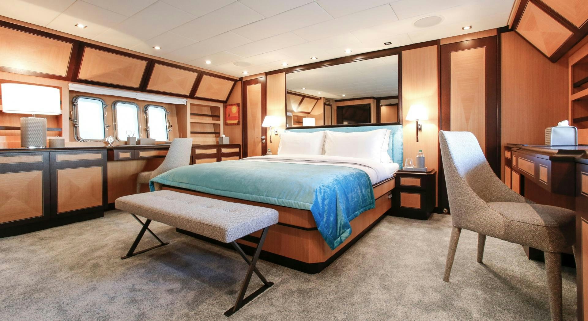 a bedroom with a bed and a chair aboard THE OFFICE Yacht for Sale