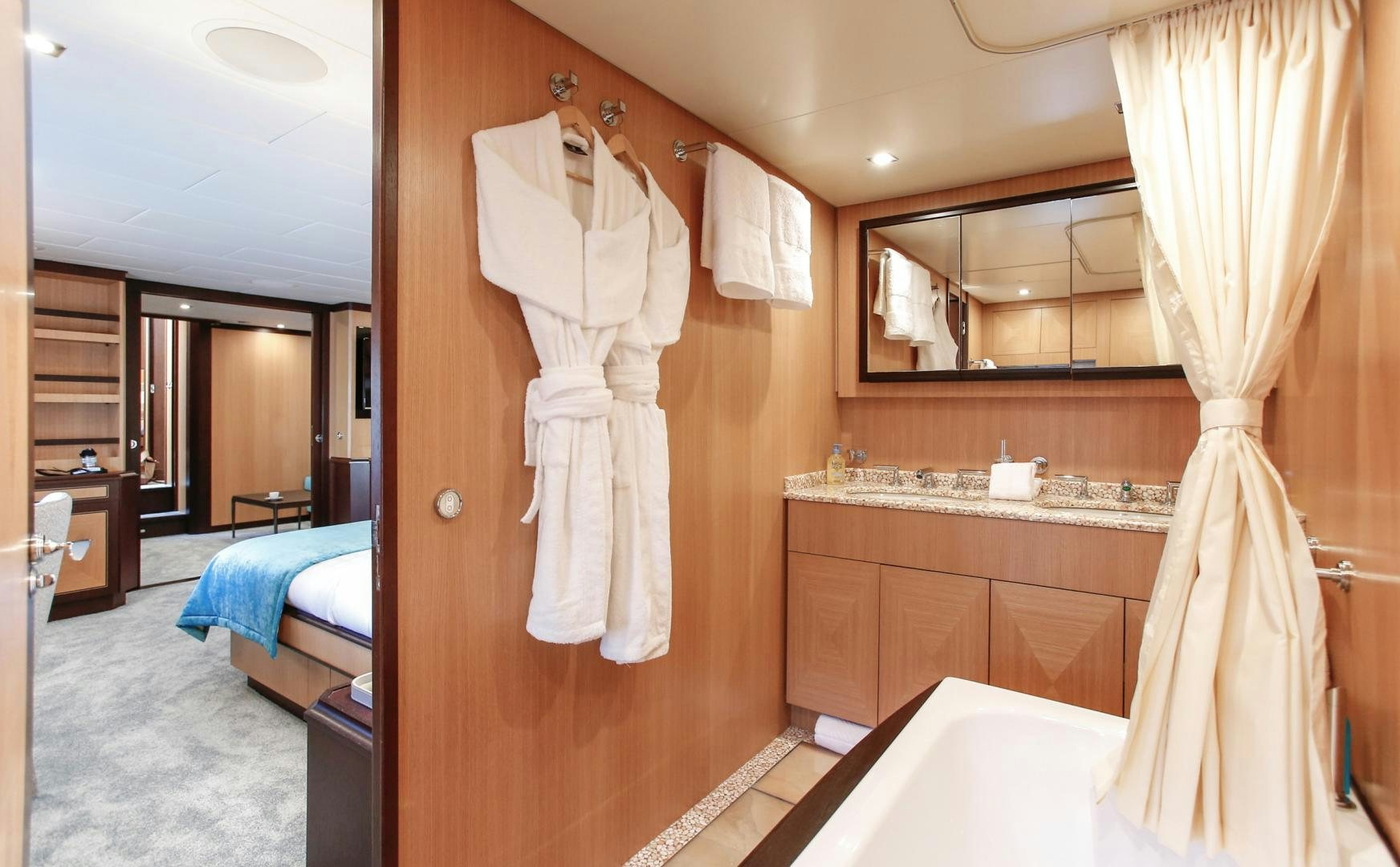 a bathroom with a robe on the wall aboard THE OFFICE Yacht for Sale