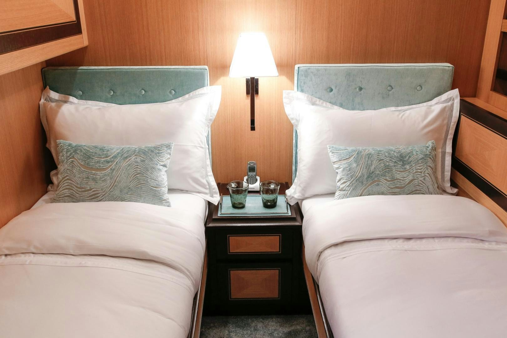 a bed with pillows and a lamp aboard THE OFFICE Yacht for Sale