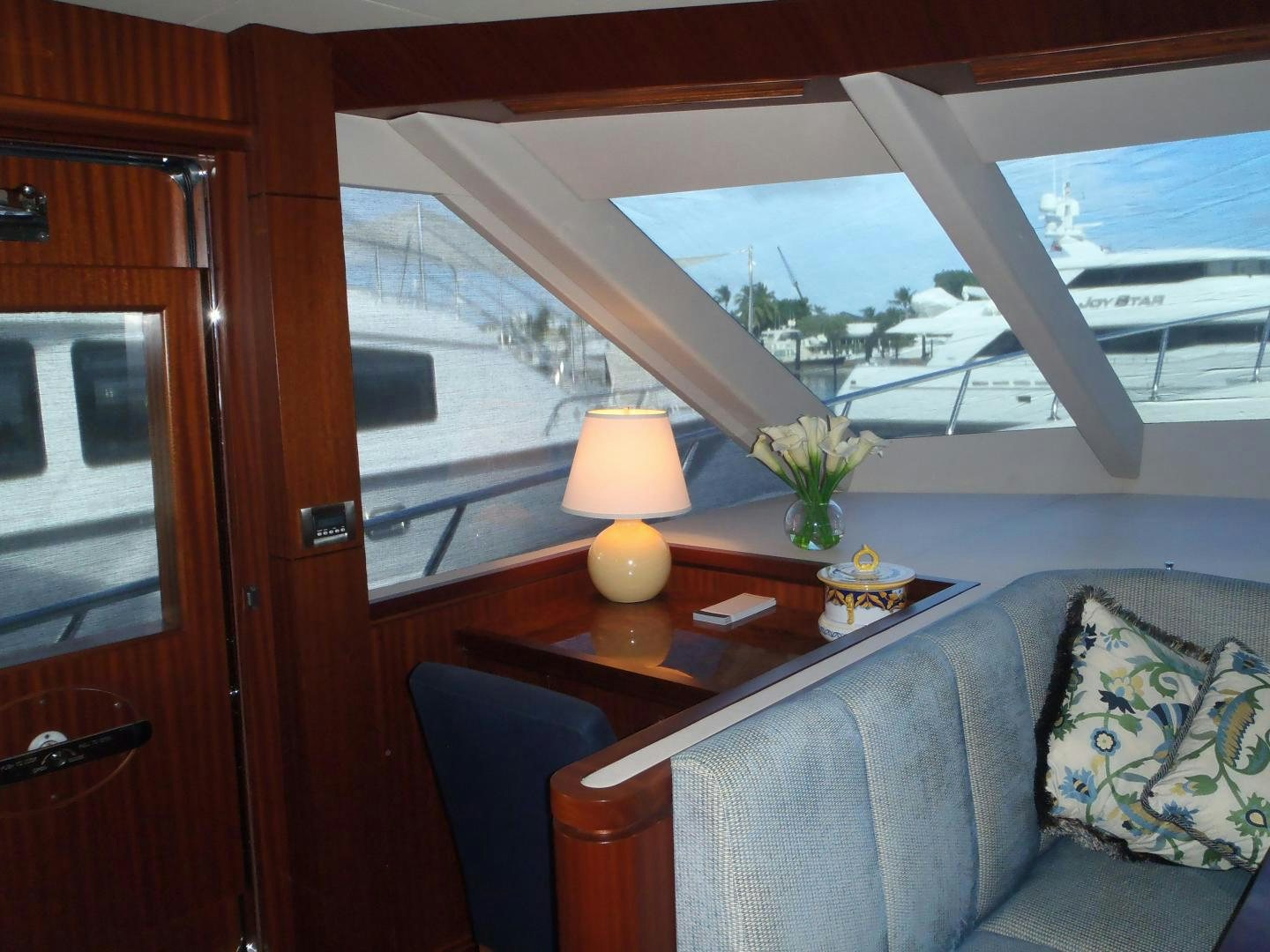 a room with a couch and a table with a lamp on it aboard CLAYPEN Yacht for Sale