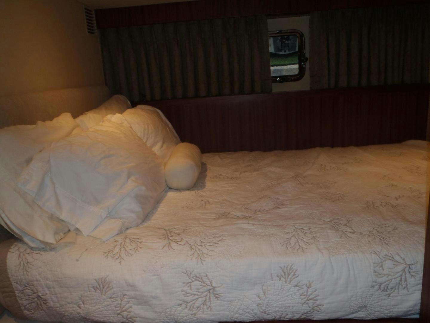 a bed with a pillow and a television on it aboard CLAYPEN Yacht for Sale